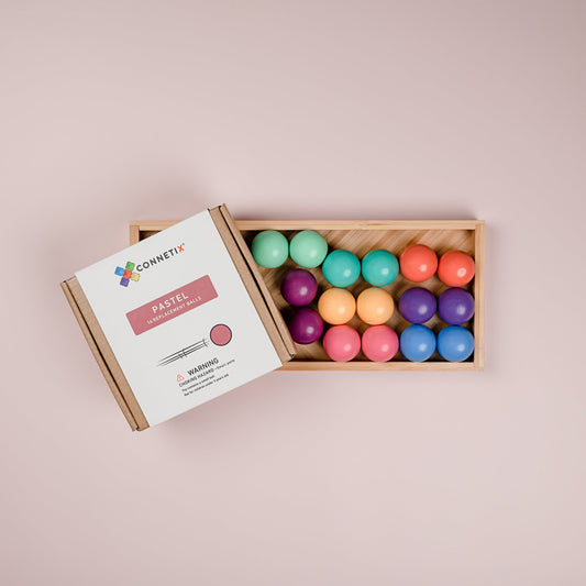 Zestien houten CONNETIX ballen in acht zachte pastelkleuren in bakje
