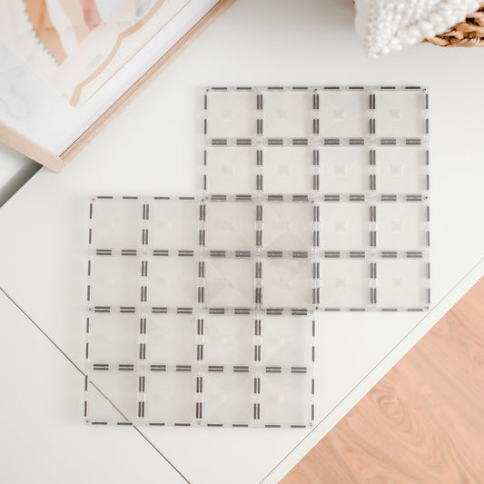 Twee transparante magnetische basisplaten van CONNETIX van 30 x 30 cm op tafel