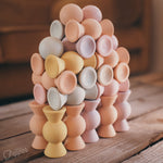Chill Pepper Sweets Peachy Pastels, toren van pastelkleurige houten snoepjes op een houten tafel