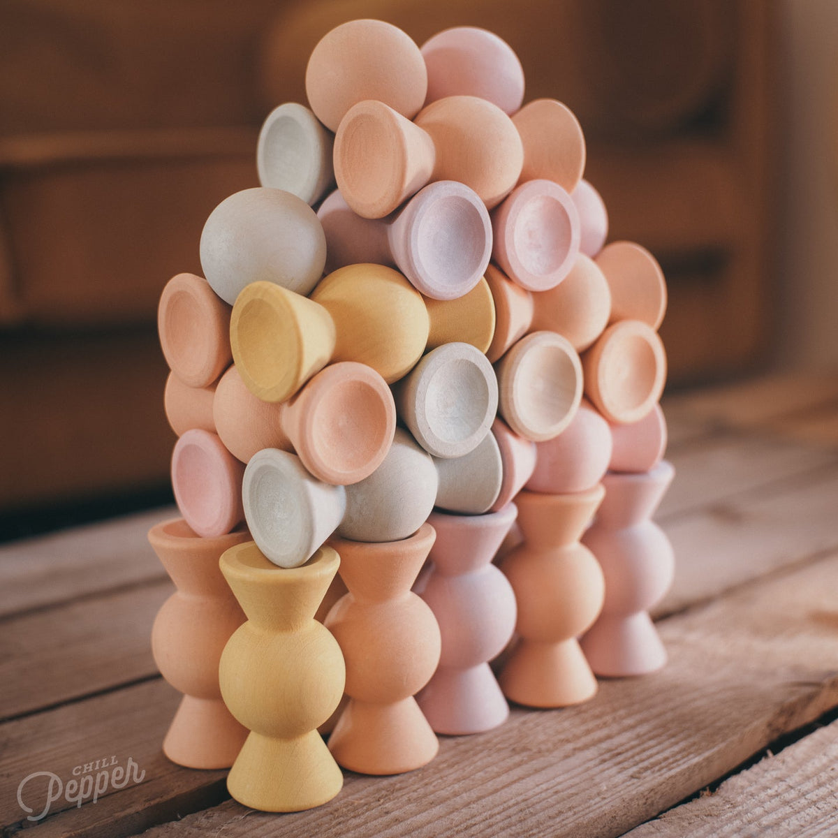 Chill Pepper Sweets Peachy Pastels, toren van pastelkleurige houten snoepjes op een houten tafel