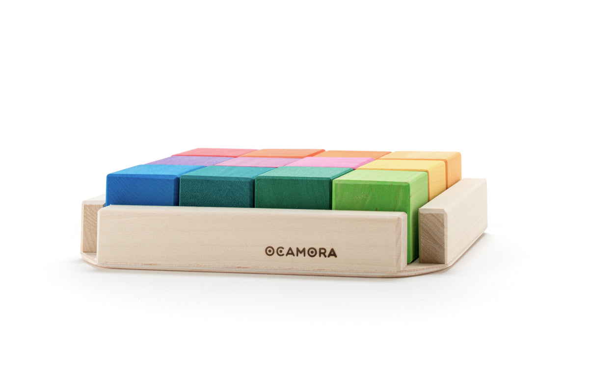 Twaalf houten regenboogkubussen van Ocamora in een houten tray, liggend