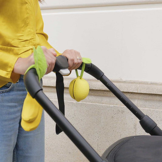 Oli&Carol speenkokertje Lou the Lemon, citroenvorm met mousseline blad aan kinderwagen