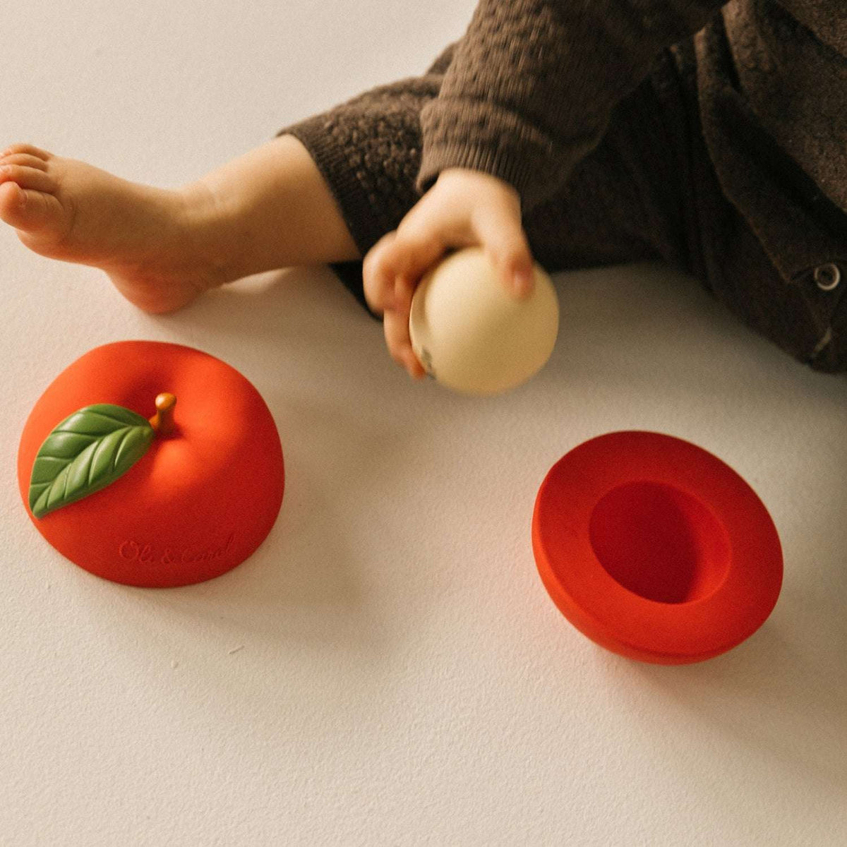 Oli&Carol Stack&Bounce Apple, appelvormig stapel- en rammelspeeltje met babyhandje