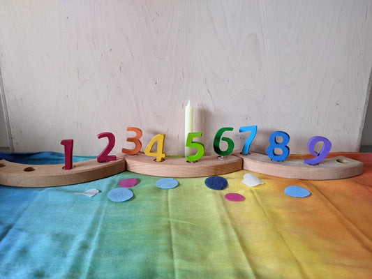 Vossebos houten cijferstekers in regenboogkleuren, geplaatst in de verjaardagsring