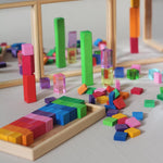 Honderd vierkante houten mozaïekstenen van Bauspiel in tien kleuren en een houten frame. Gecombineerd in fantasiespel