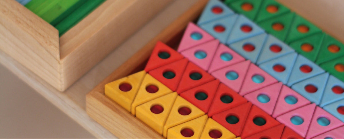 Honderd kleine houten regenboogdriehoeken van Bauspiel met ingelegde fonkelstenen in kast