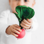 Oli&Carol bijtring Ramona the Radish, vorm van een radijsje met blad in kinderhand