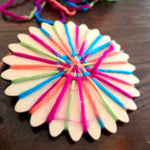 Houten weefwondertje met regenboogkleurig garen half geweven