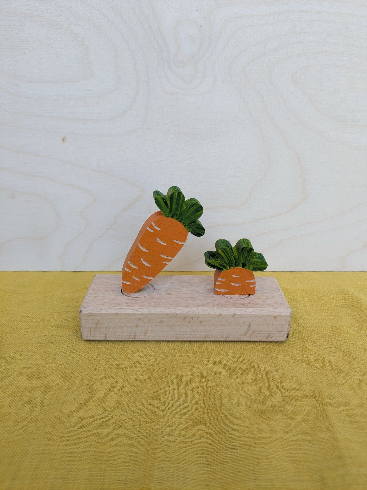 Vossebos steker wortel met loof, op een houten voet